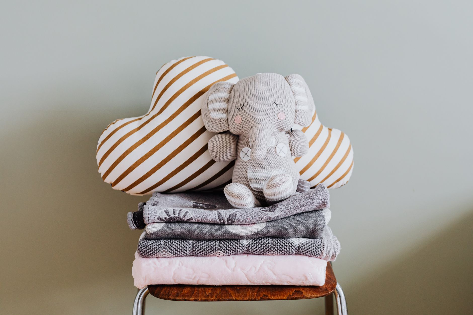 A soft, neutral-toned nursery corner with a plush toy and blankets